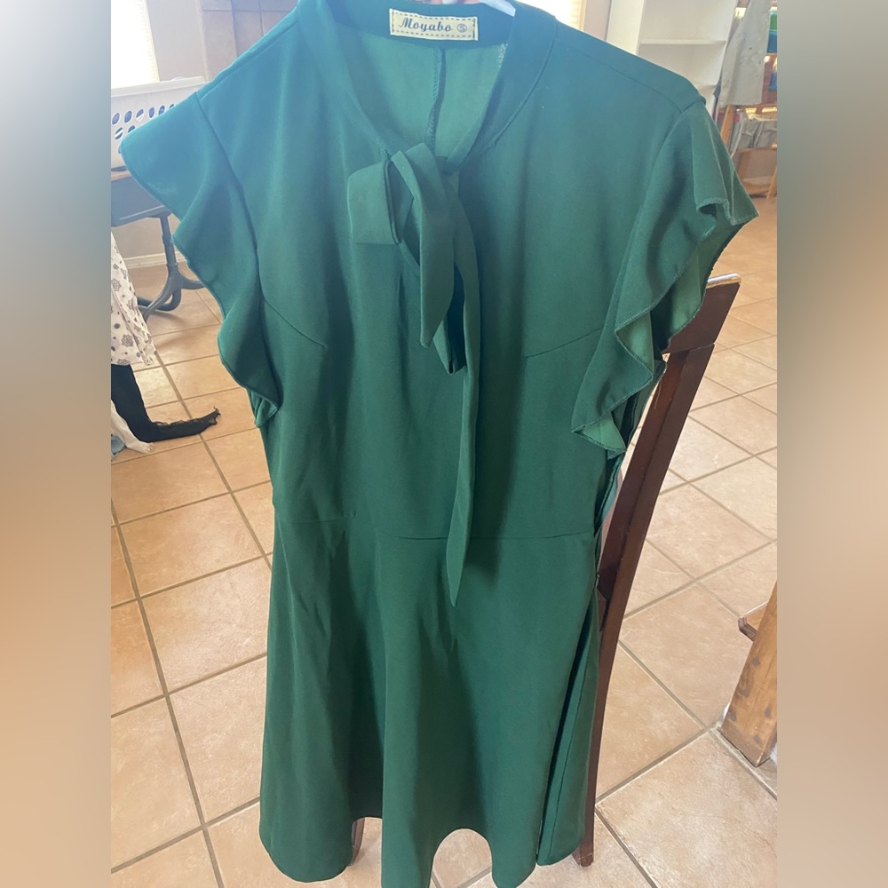 Green dress with bow around neckline.